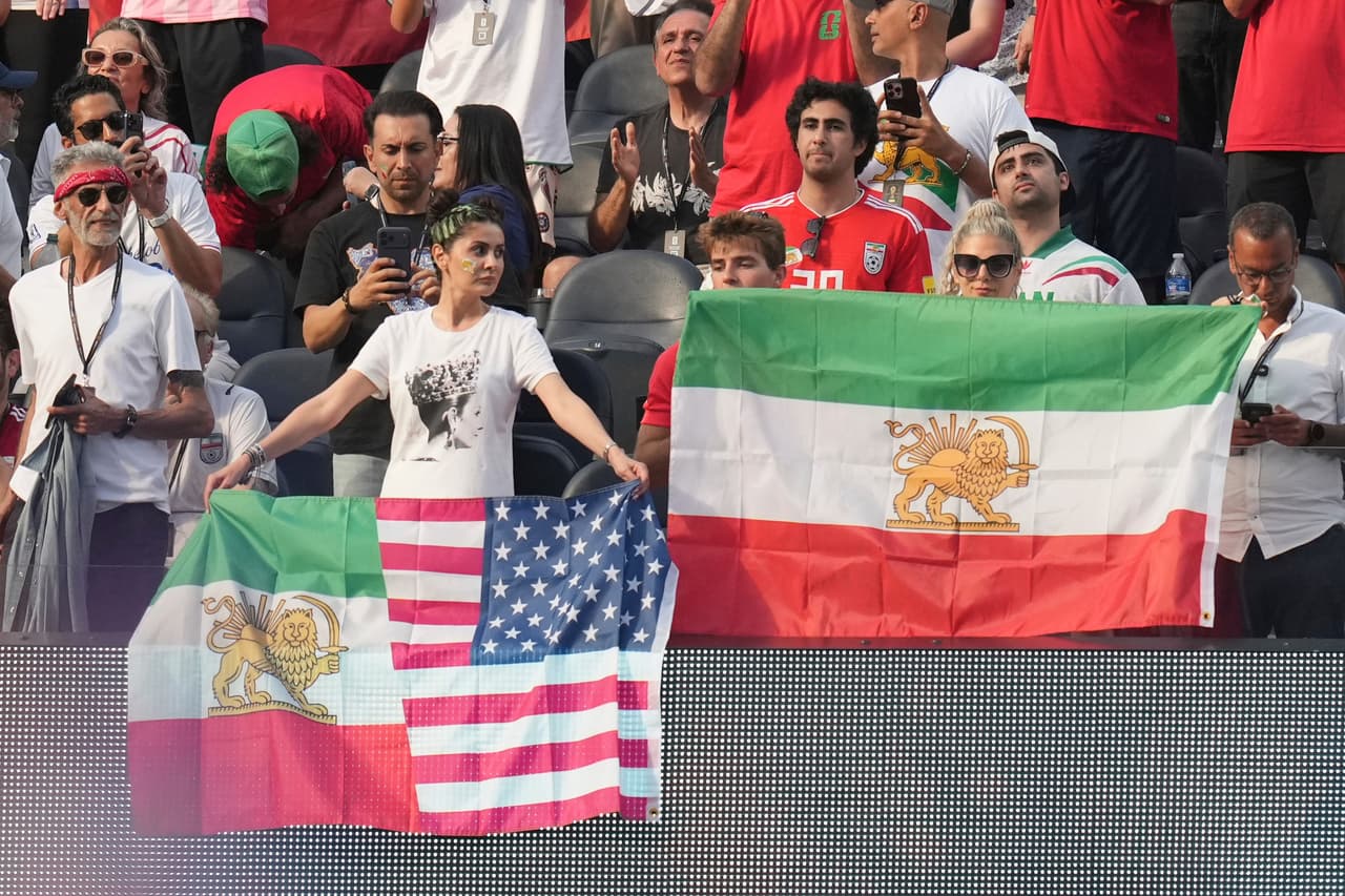 Unos aficionados exhiben banderas de Irán anteriores a la revolución durante el partido de fútbol del Grupo G de la Copa del Mundo entre Irán y Nueva Zelanda.