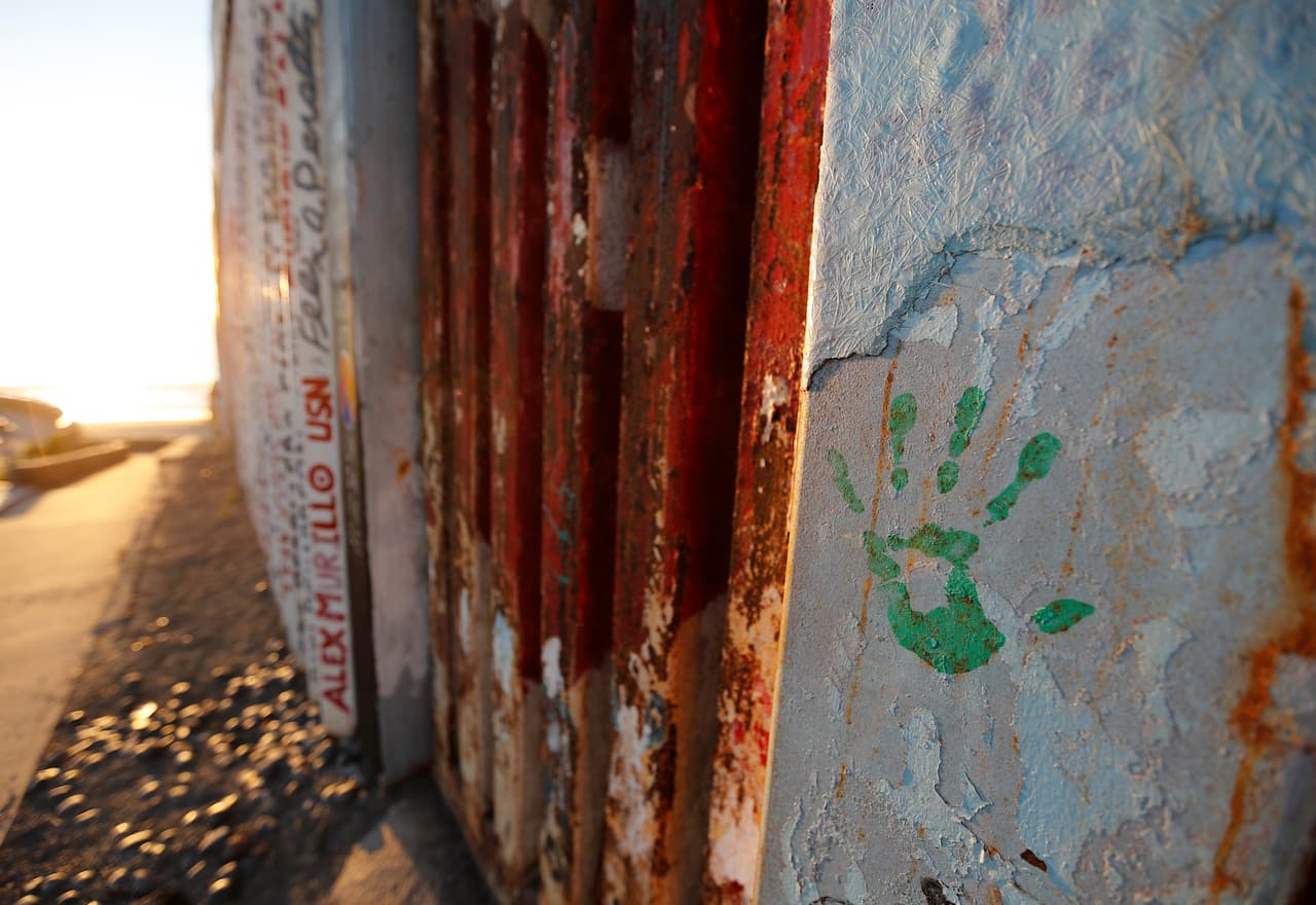 La huella de una mano en recuerdo de los migrantes que fueron asesinados o están desaparecidos, en el muro que separa Tijuana, México, de San Diego, en Tijuana. Esta foto fue tomada el 16 de octubre de 2018. (AP Foto/Gregory Bull)