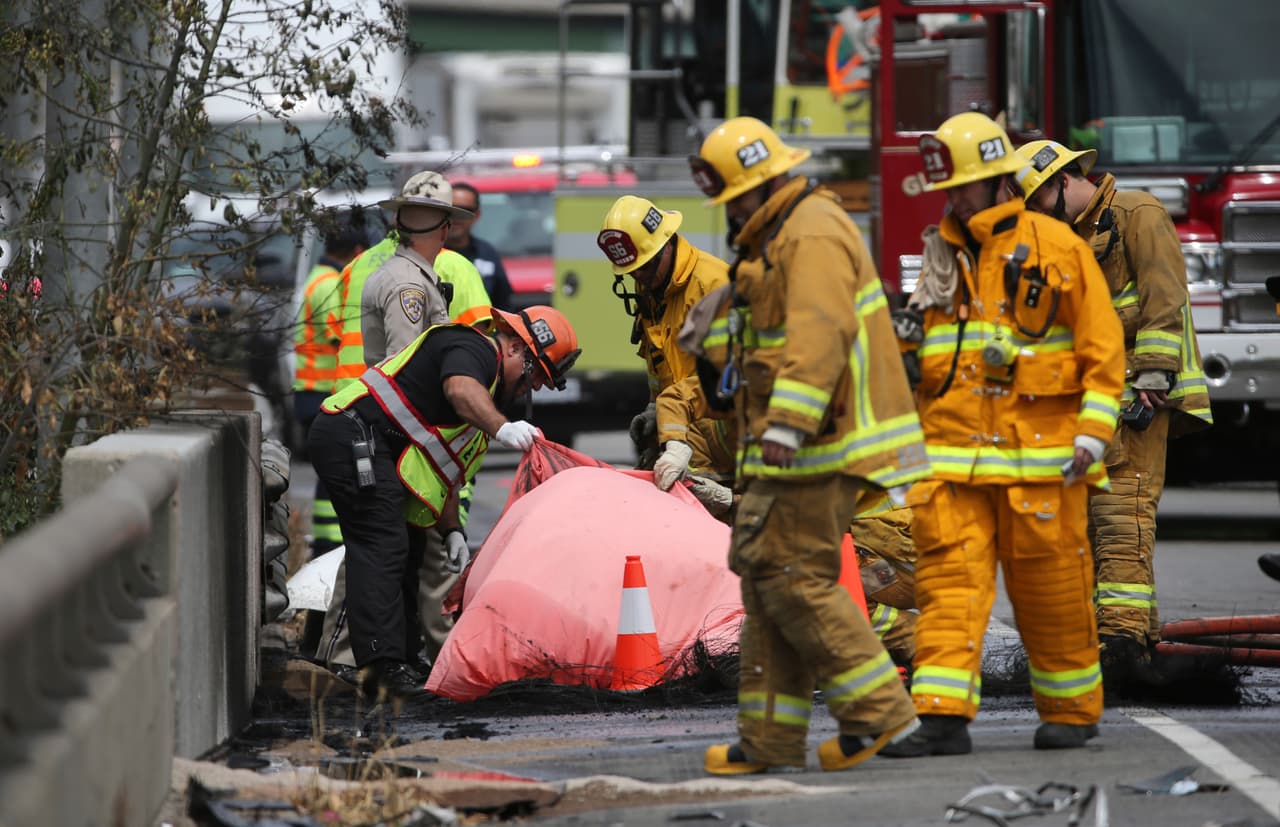 Bomberos revisan los restos de una persona incinerada.