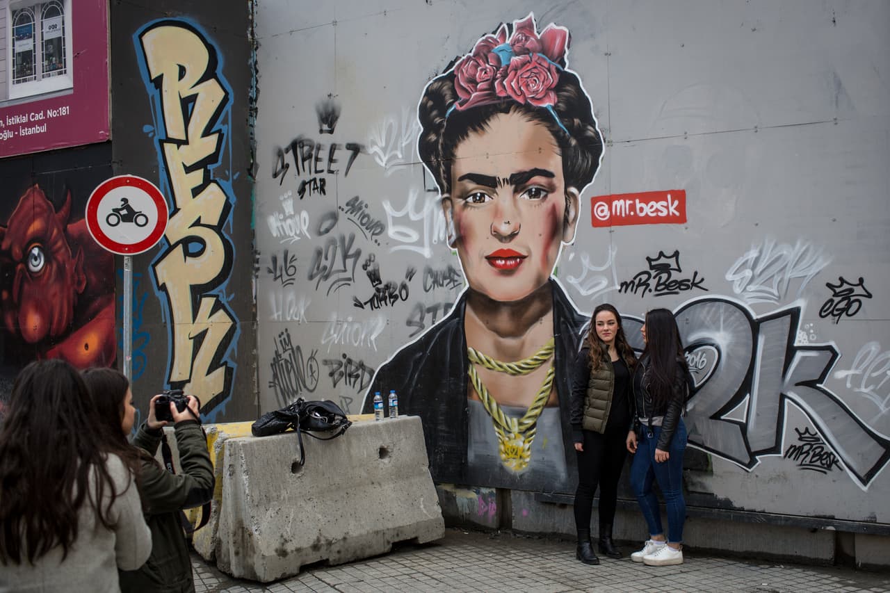 Dos mujeres posan para una foto junto a una pintura de Frida Kahlo hecha
<b> sobre un muro de las calles de Estambul, Turquía. </b>