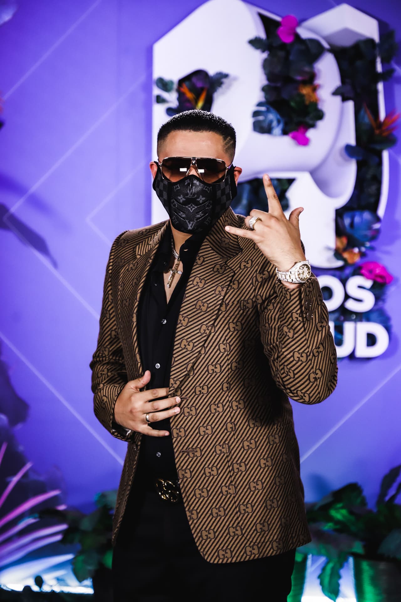 Para su llegada a Premios Juventud, Edwin Cazares, de Grupo Firme, eligió un saco Gucci, camisa y pantalones negros y un cubrebocas Louis Vuitton.