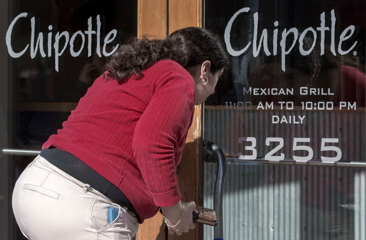 A woman looking to eat lunch looks through the locked front door of the Chipotle Restaurant February 8, 2016, in the Washington, DC, commmunity of Georgetown. Chipotle restaurants across the US are temporarily closing until 3pm EST in an effort to educate 60,000 employees about the food-borne illnesses that have rocked the company in recent months. Food safety protocols will also be explained in the meeting. / AFP / PAUL J. RICHARDS (Photo credit should read PAUL J. RICHARDS/AFP/Getty Images)