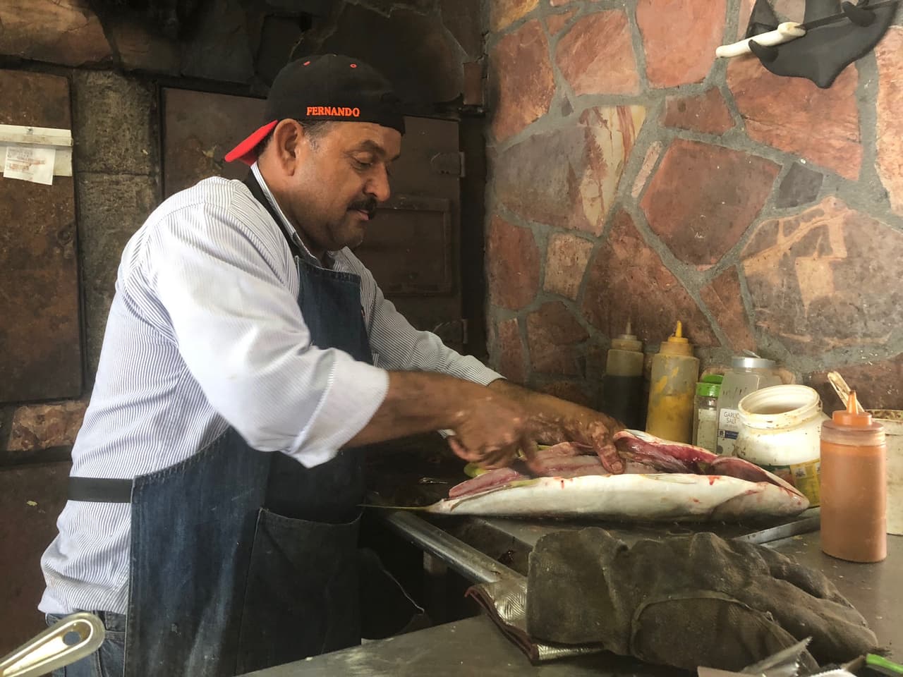 Uno de los propietarios de un restaurante del lugar prepara uno de los pescados frescos acabados de traer del Mar de Cortés antes de meterlo al horno.