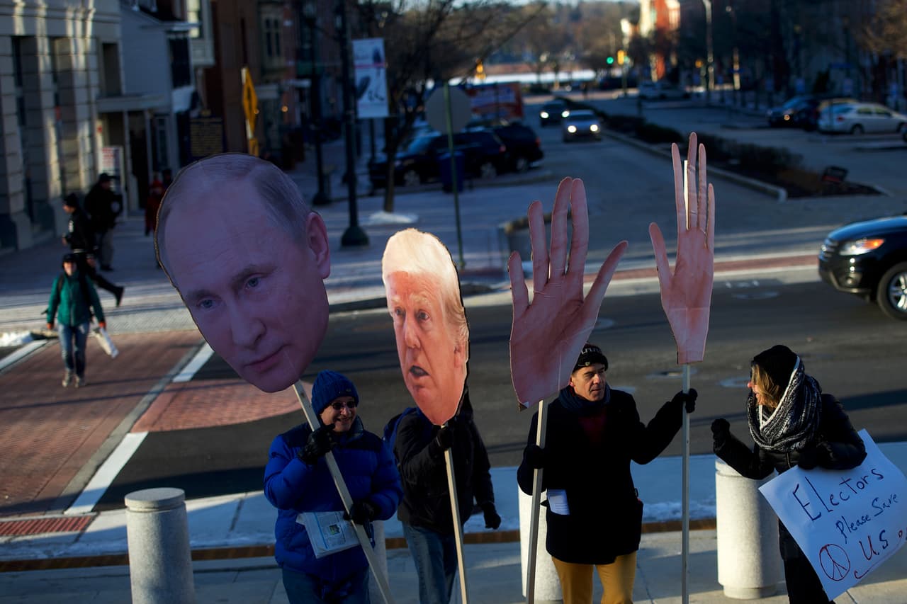 HARRISBURGO, PENNSYLVANIA.- Manifestantes contra Donald Trump muestran carteles de cartón del entonces presidente electo y de Vladimir Putin antes de que el Colegio Electoral emitiera sus votos en noviembre pasado. Trump ganó en Pennsylvania por menos del 1%, por sobre Hillary Clinton.