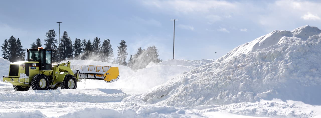 Una excavadora recogía este lunes montones de nieve acumulada en el Glacier Park International Airport