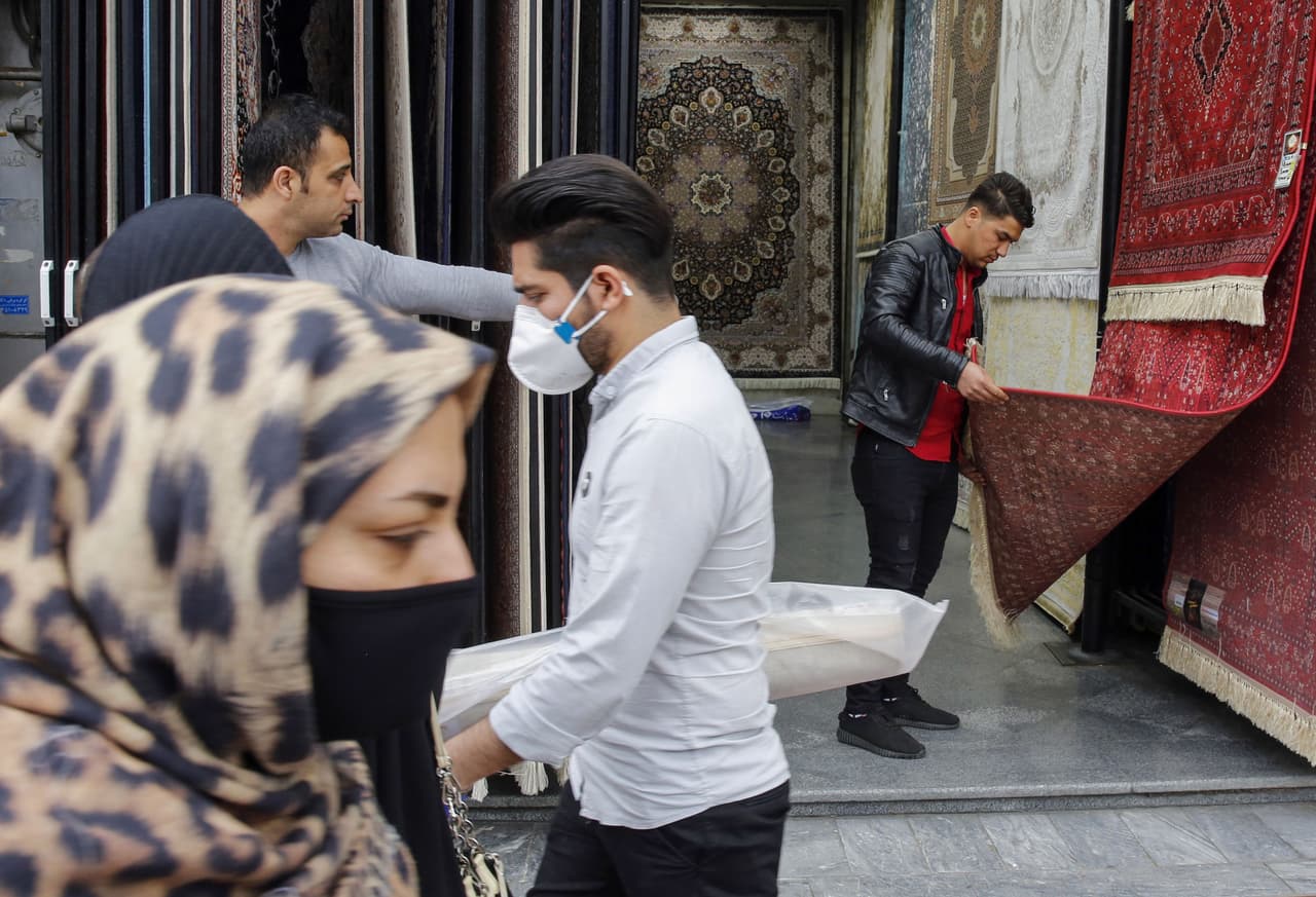 Iraníes con mascarillas protectoras en la capital iraní, Teherán.