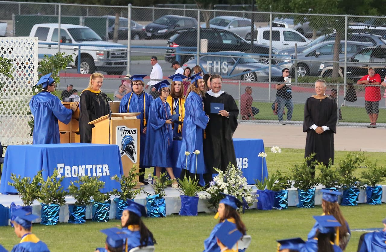 Recibiendo su diploma en el escenario.