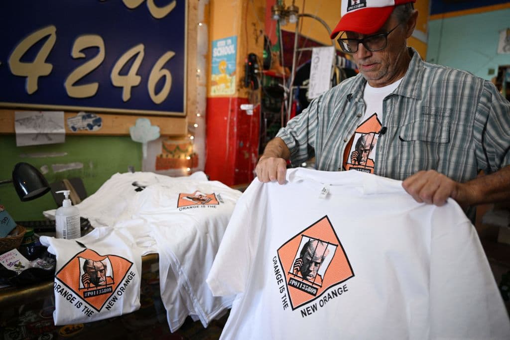 Otra gran diferencia de las piezas de Y-Que es el uso del humor, ausente en las de la campaña del expresidente republicano de EEUU. Por ejemplo, esta que modela Wyatt, alude al supuesto tono naranja de la piel de Donald Trump. Lo comparan con la recordada serie de Netflix, 'Orange is the New Black', dando a entender que será encarcelado. La camisa incluye además su número de preso, PO1135809.