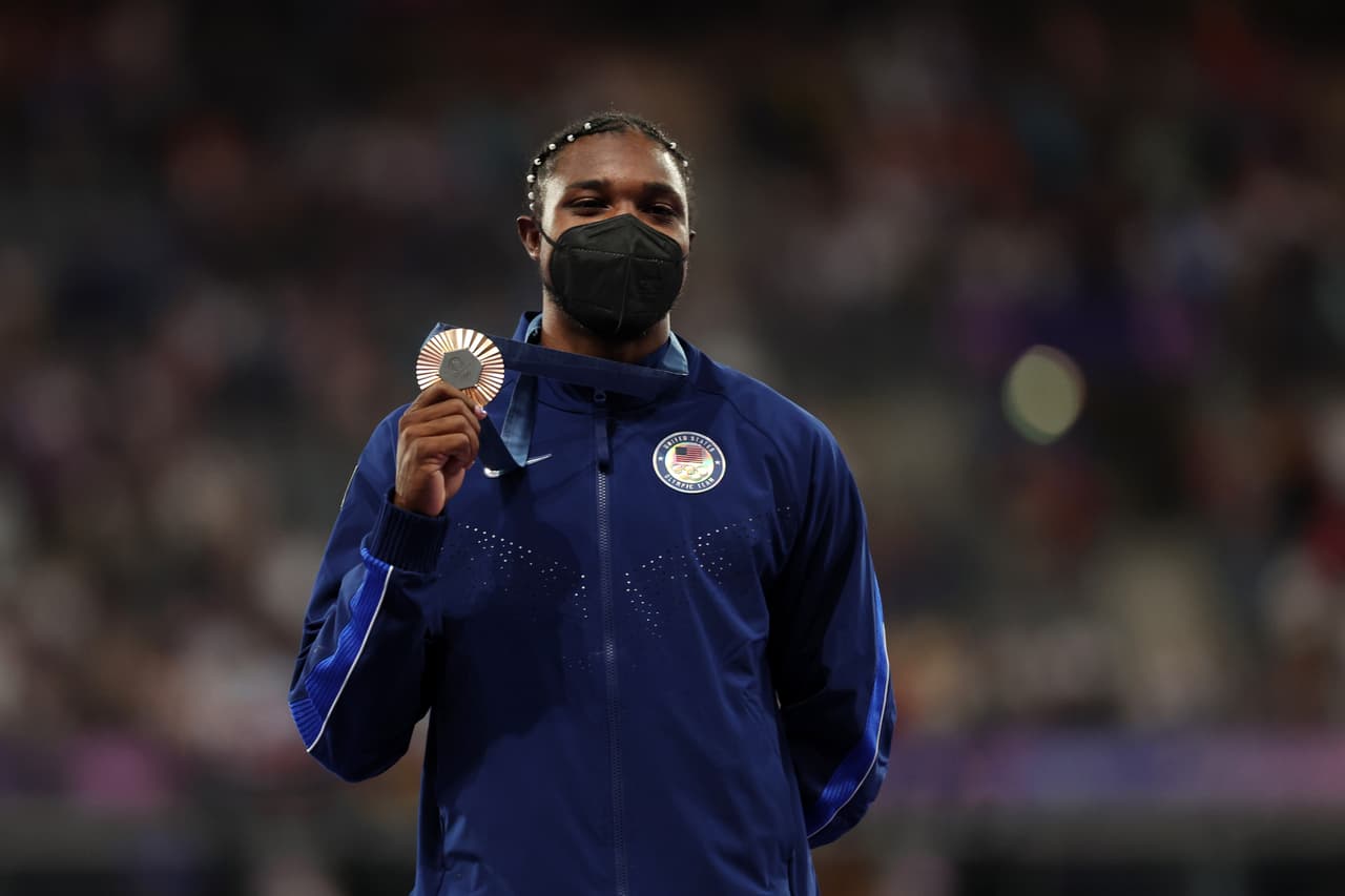 Noah Lyles recoge su medalla con mascarilla