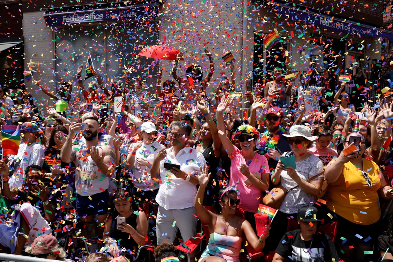 Arrojan confeti sobre las personas que participan o asisten como observadores en el desfile de la comunidad LGBTQ en Manhattan.