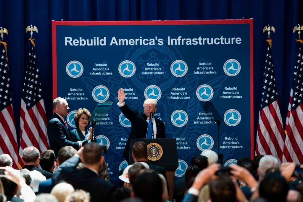 TOPSHOT - US Secretary of the Interior Ryan Zinke (L) and US Secretary of Transportation Elaine Chao (C) watch US President Donald Trump speaks wave during his visit to the US Department of Transportation June 9, 2017 in Washington, DC. Trump visit of the Transportation Department is part of a White House push to overhaul America's infrastructure. / AFP PHOTO / Brendan Smialowski (Photo credit should read BRENDAN SMIALOWSKI/AFP/Getty Images)