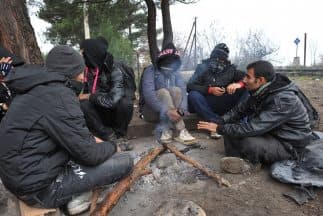 Un grupo de inmigrantes intenta calentarse en un día frío en Macedonia.