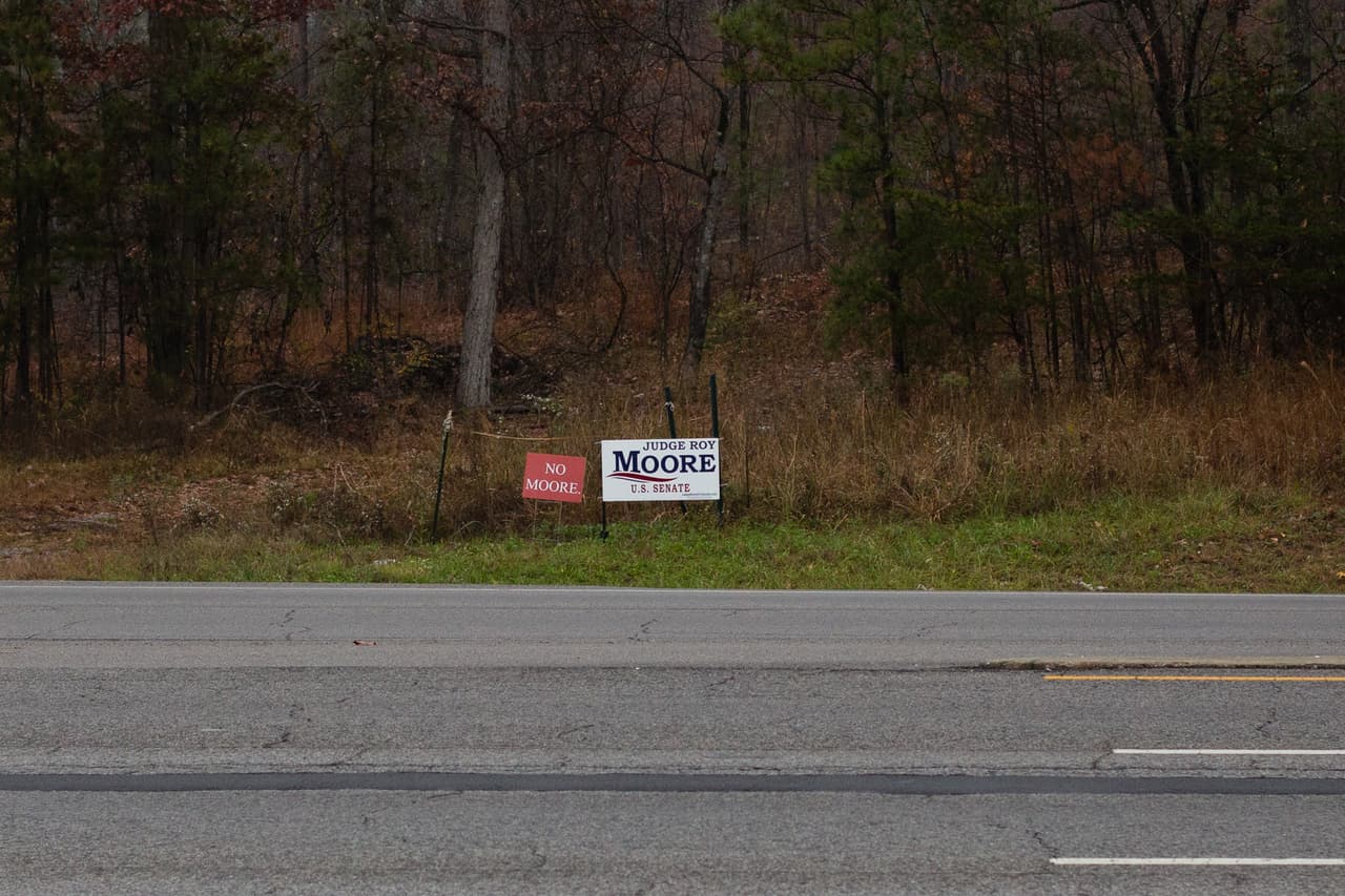 El ingeniero industrial Michael Morris, de 55 años, imprimió cientos de letreros de "No Moore", que ahora se ven en todo Birmingham. Aquí, uno fue estacado junto a un letrero que apoya al candidato republicano Roy Moore.