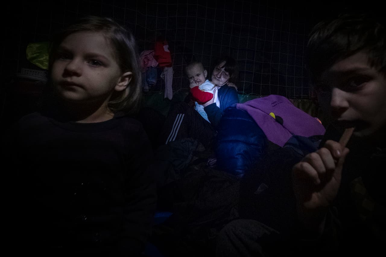 Irpin: Dos niños y una abuela que sostiene a su nieto se refugian en una iglesia.
<br>