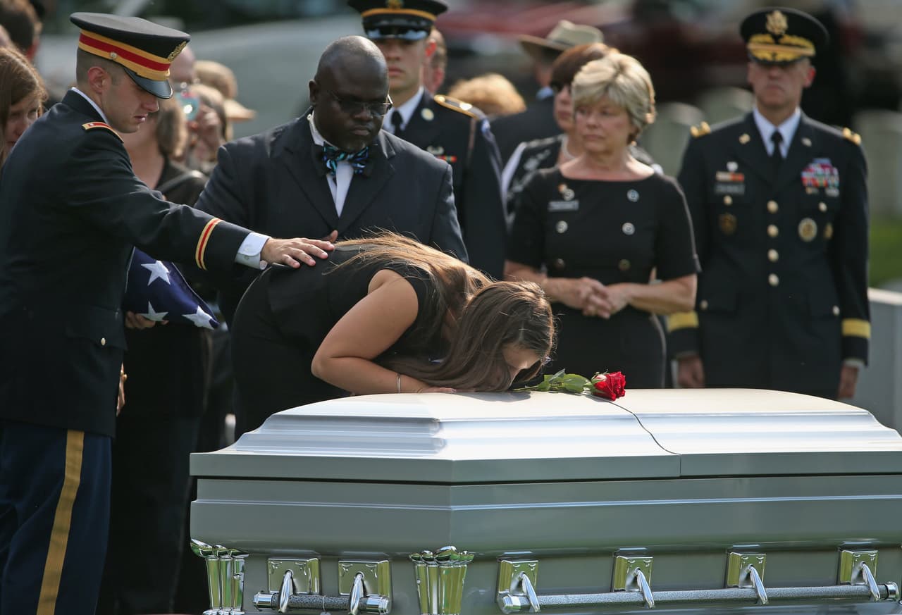El Teniente Matthew Green (izquierda) y su hermana Amelia Green lloran sobre el ataúd de su padre, el General de División del Ejército Harold J. Greene. Fue durante su funeral en el Cementerio Nacional de Arlington, el 14 de agosto de 2014. 
<br>
<br>Greene fue asesinado a tiros cuando visitaba la academia militar nacional de Afganistán en Kabul, Afganistán. Fue el oficial del Ejército de mayor rango muerto en combate desde la Guerra de Vietnam.
<br>