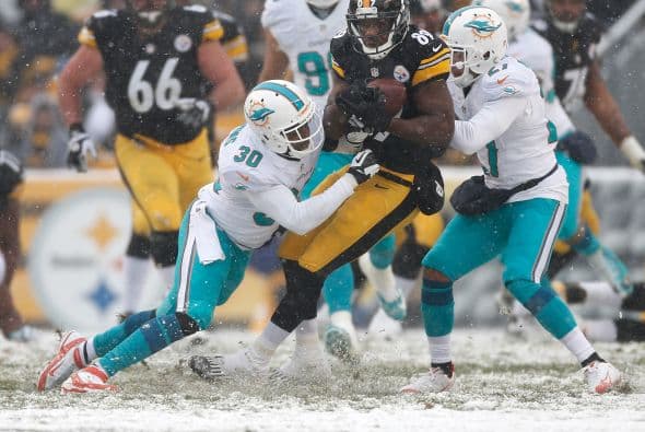 Los fanáticos de los Dolphins ya no hablan de la controversia Incognito/Martin, ni si Ireland o Philbin estarán con el equipo en el 2014, sino que pasan horas calculando… ¡porque tenemos chance de ir a los playoffs! Al principio de la temporada, y sobre todo, después de perder -casi deshonrosamente- contra Tampa Bay y Buffalo, los comentarios sobre Miami eran negativos. Qué si las novatadas, qué si Tannenhill, qué si el running game, qué si la línea ofensiva, que si… qué se yo… Pero ahora, las cosas han cambiado y solo se mencionan las posibilidades que tenemos de jugar en enero. ¡Ay, bendito! Bueno, después de este encontronazo con los portadores de las terribles toallas amarillas, donde salimos vencedores … por media pulgada… 34-28, ya todo me parece posible. Arriba Tannenhill (20 de 33, para 200 yds); arriba Wake and Odrich; arriba Thomas (105 yds, un TD en 16 acarreos); arriba Clay con sus dos TD y arriba Philbin, que mantiene el invicto en la revisión de las jugadas (obtuvo el cambio de “incomplete pass” a TD de Hartline). ¡Arriba, Dolphins, seguimos cuesta arriba!