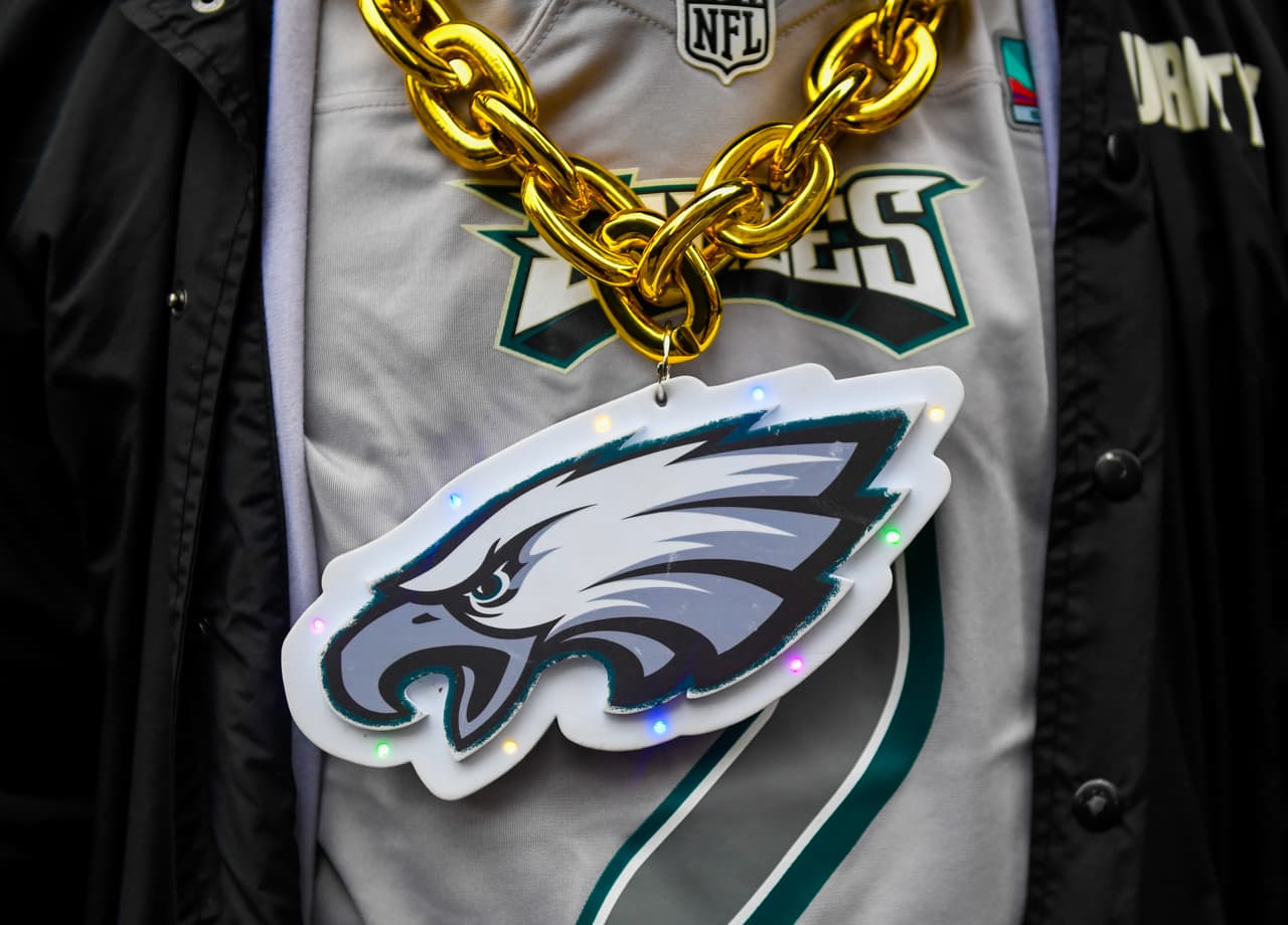 Un aficionado de los Philadelphia Eagles que lleva una gran cadena con el logotipo de los Eagles camina por Broad Street después de que se cerrara por posibles celebraciones después del Super Bowl LIX contra los Kansas City Chiefs el 9 de febrero de 2025 en Filadelfia, Pensilvania. Los Eagles buscan ganar su primer Super Bowl desde 2018 y evitar un "triplete" de Kansas City.