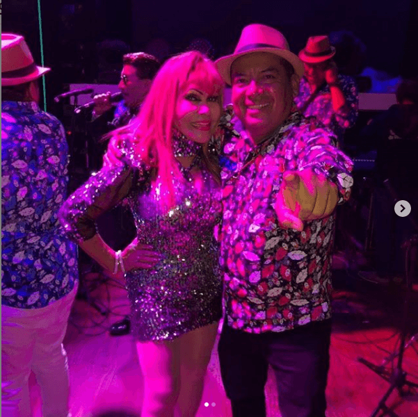 En otro momento de la celebración portó un vestido plateado, corto, con manga a medio brazo y cuello de tortuga. En la foto está acompañada por un integrante del grupo 
<b><a href="https://www.instagram.com/loscampesinos_hermanos_fuentes/" target="_blank">Los campesinos de Bambamarca</a></b>, quienes amenizaron el evento.