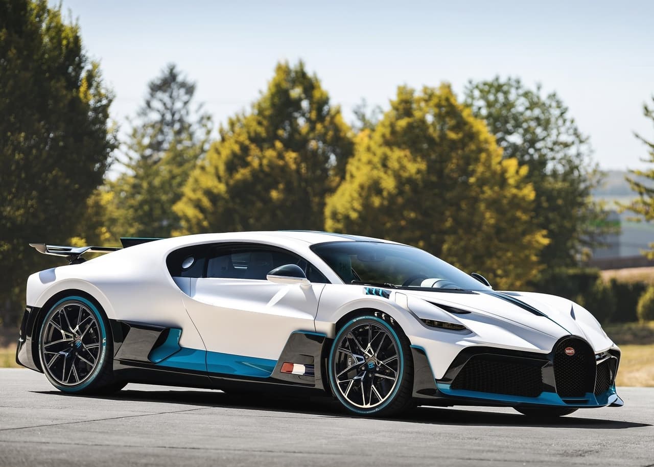 <h3 class="cms-H3-H3">6. Bugatti Divo</h3>
<br>
<br>
<b>Precio: </b>5.9 millones de dólares
<br>
<br>Este superauto fue desarrollado con la intención de ofrecer un mejor rendimiento en las pistas con curvas. Todos sus elementos relacionados al control del flujo de aire como las entradas de aire y alerones muestran un terminación en fibra de carbón. Las propiedades aerodinámicas del modelo fueron acentuadas por trabajo en los detalles, la tapa frontal por ejemplo contiene entradas de aire que reducen el área plana del vehículo y mejoran el flujo del aire al frente del vehículo mejorando su su eficiencia aerodinámica. Además, fue bautizado en honor al corredor francés Alberto Divo, doble campeón de la difícil carrera siciliana Targa Florio en 1925 y 1928, en ambas ocasiones a bordo de un Bugatti Type 35. El Bugatti Divo está equipado con el mismo motor que utiliza el Chiron, su compañero de establo. Se trata de una unidad de 16 cilindros en W, que bajo el capó del Divo desarrolla 1,480 caballos de fuerza.