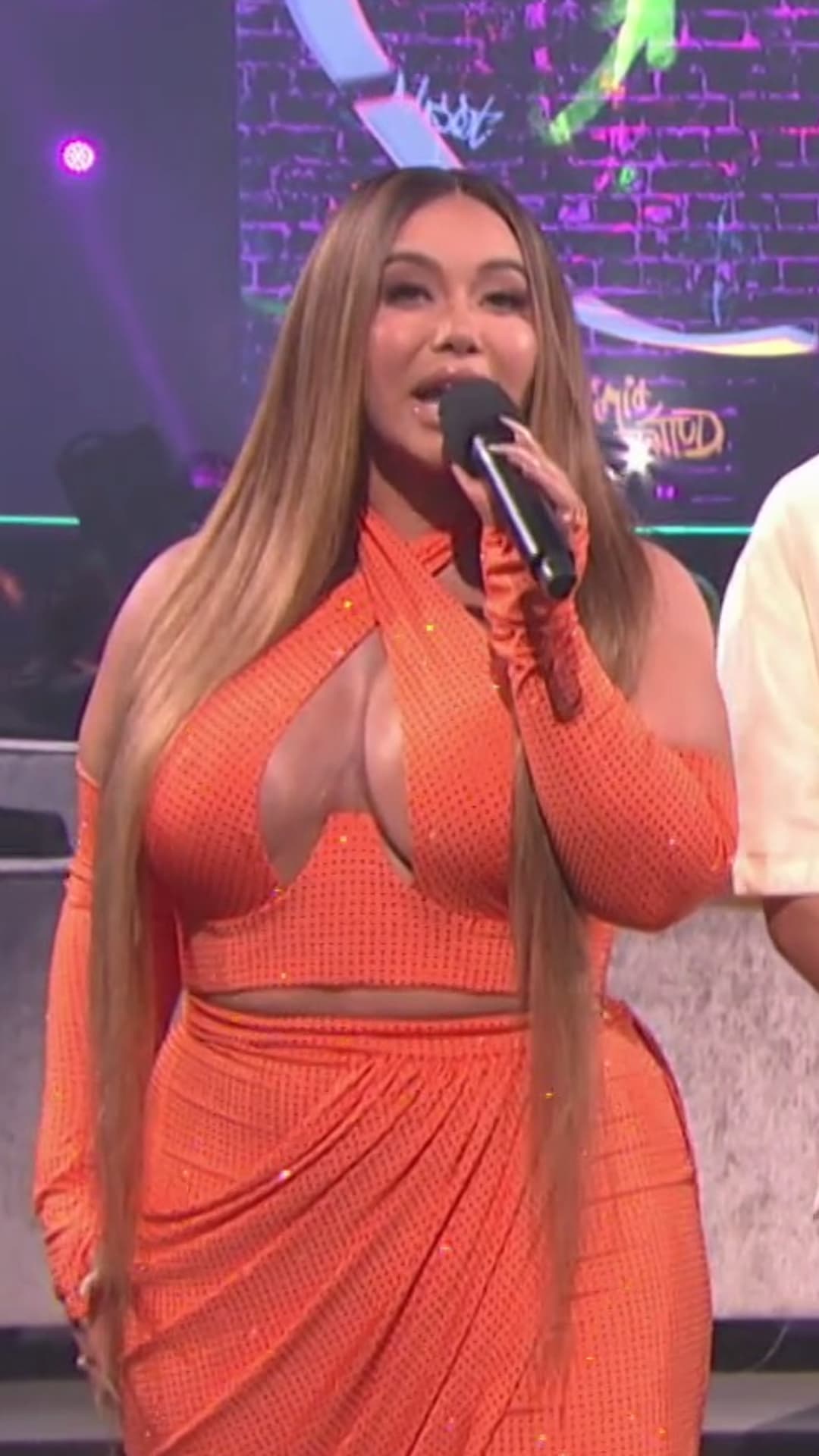 El diseño hecho exclusivamente para ella, consistía en tres piezas con hulter top y mangas desmontables y, de nuevo, un pantalón de cintura alta, con un drapeado muy coqueto en la parte frontal. Chiquis sorprendió con estas extensiones de 40” que su estilista de cabello Tony Ibarra diseñó y pintó específicamente para ella.