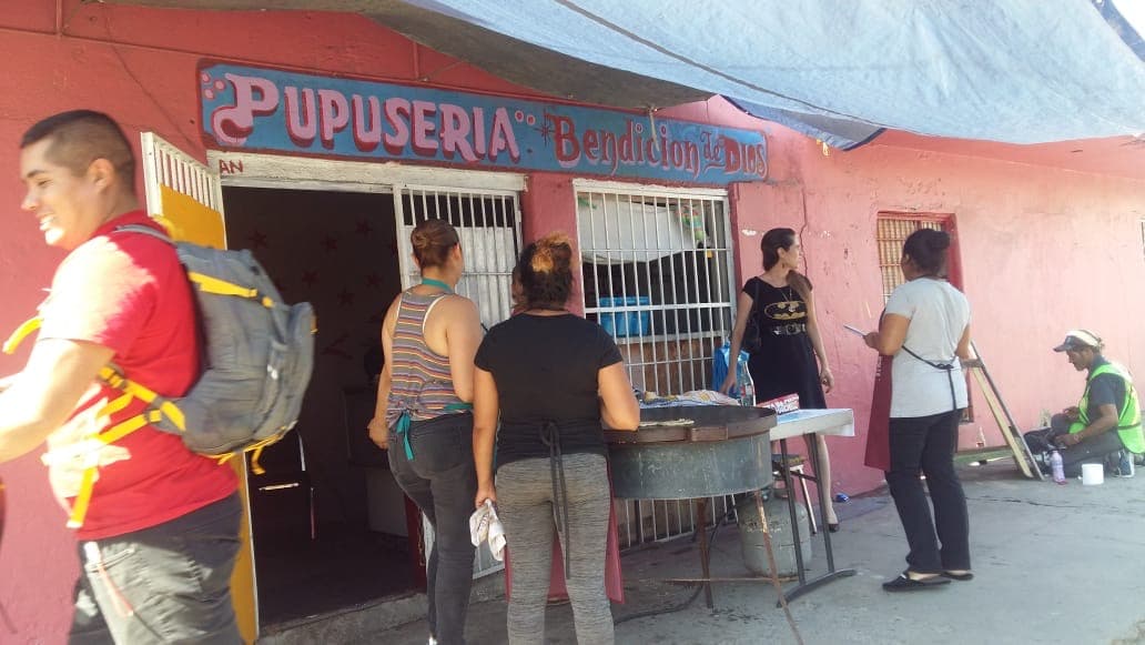 Migrantes venden pupusas para mantener un albergue en Tijuana
