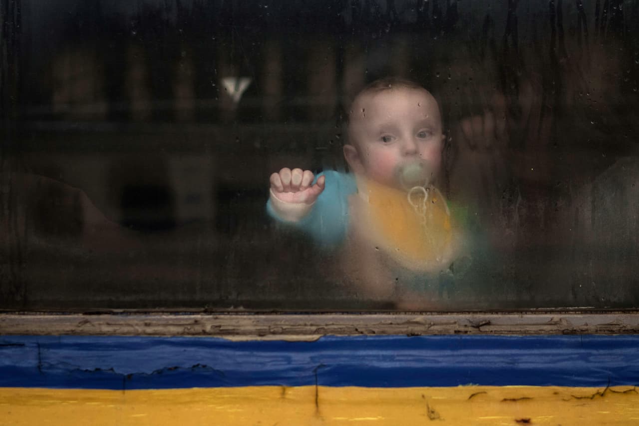 Un bebé en las piernas de su madre dentro de un tren que sale con refugiados ucranianos de Lviv, al oeste de Ucrania, el 2 de marzo. Las sanciones de occidente ya han empezado a complicar la economía rusa, que enfrenta una severa devaluación de su moneda en los últimos días.