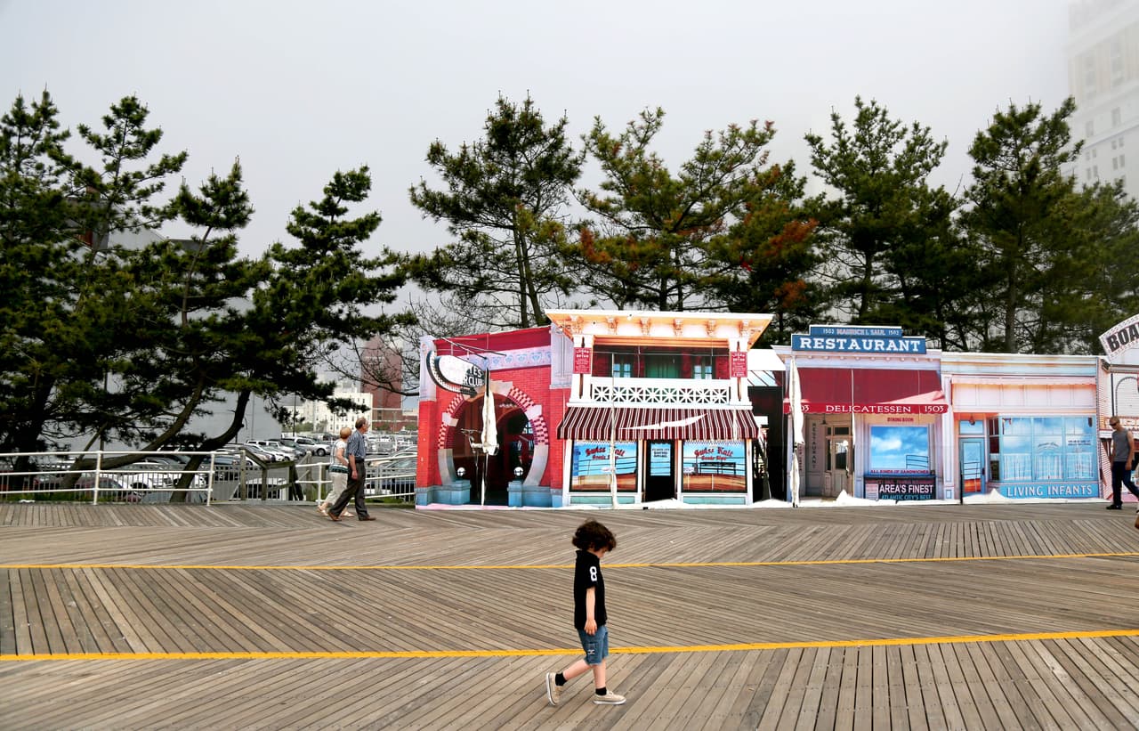 Un niño camina sobre el paseo tablado frente a decoración que asemeja los antiguos negocios de la primera época de oro de la ciudad, en los años 20. A finales de los años 80, Donald Trump le dio un impulso a Atlantic City que ahora se acaba. La ciudad continúa dependiendo de una industria en declive, a medida que nuevos casinos abren en estados como Delaware, Pennsylvania y Nueva York.