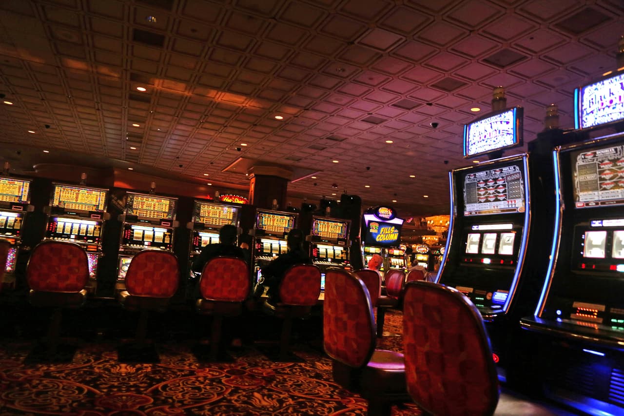 Dos hombres juegan en máquinas tragamonedas en el Trump Taj Mahal. El casino se fue a bancarrota dos veces. La primera, un año después de abrir, en 1991. La segunda, en septiembre 2014, cuando estuvo a punto de cerrar. El inversionista multimillonario Carl Icahn lo compró junto con la compañía de Trump, Trump Entertainment Resorts.