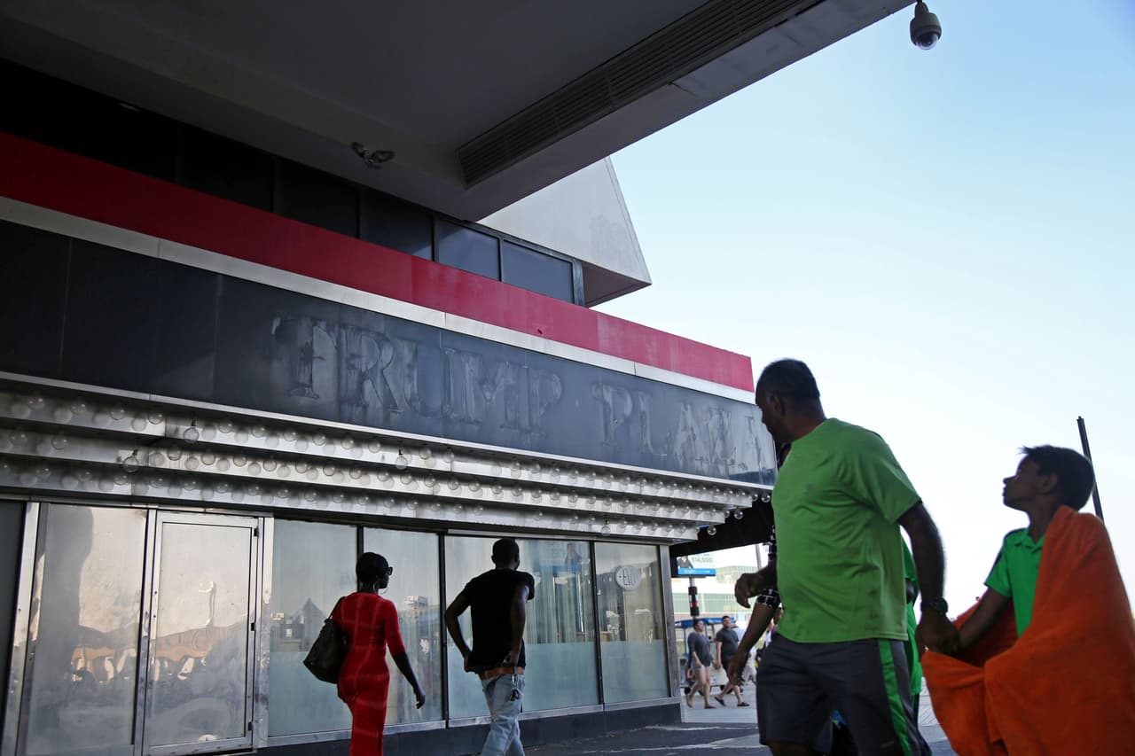 Transeúntes pasan frente al restaurante Evo del Trump Plaza sobre el paseo tablado. El restaurante cerró al mismo tiempo que el casino, en septiembre 2014, pero las mesas siguen puestas adentro.