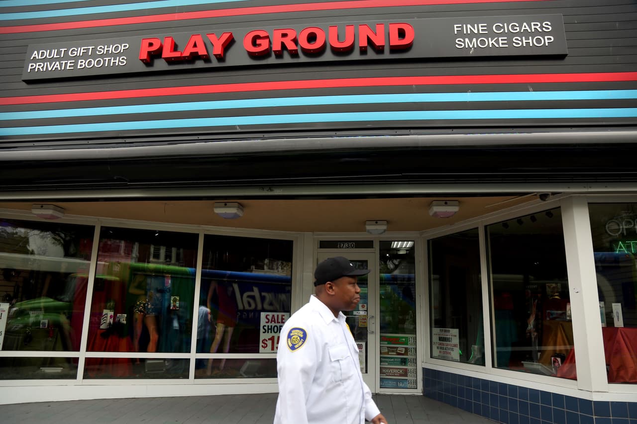 Un guardia de seguridad camina frente a una cigarrería y tienda de juguetes eróticos, el tipo de negocios que todavía prolifera en Atlantic City.