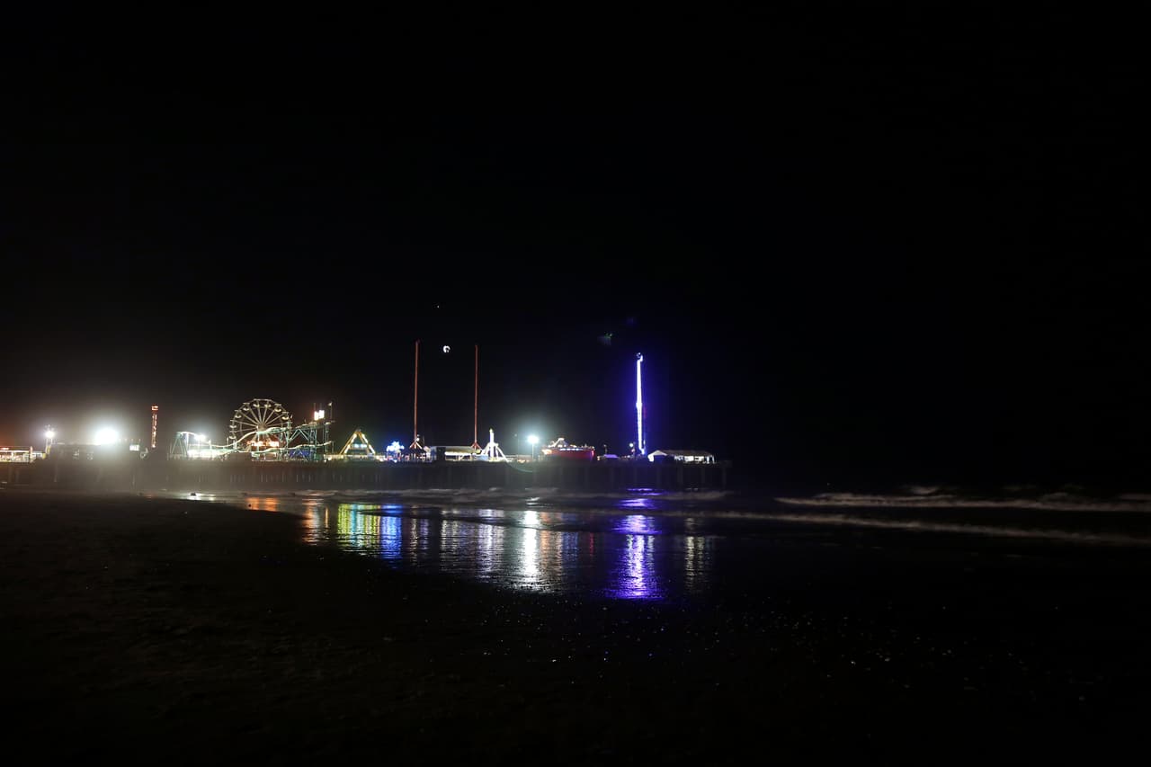 Un parque de diversiones frente al tablado alumbra en la oscuridad frente a la playa. La semana antes de las primarias en el estado el senado aprobó un paquete de ayuda financiera para evitar que el estado tome control de la ciudad, como se había propuesto en 2010, y rescatar a la ciudad de la quiebra.