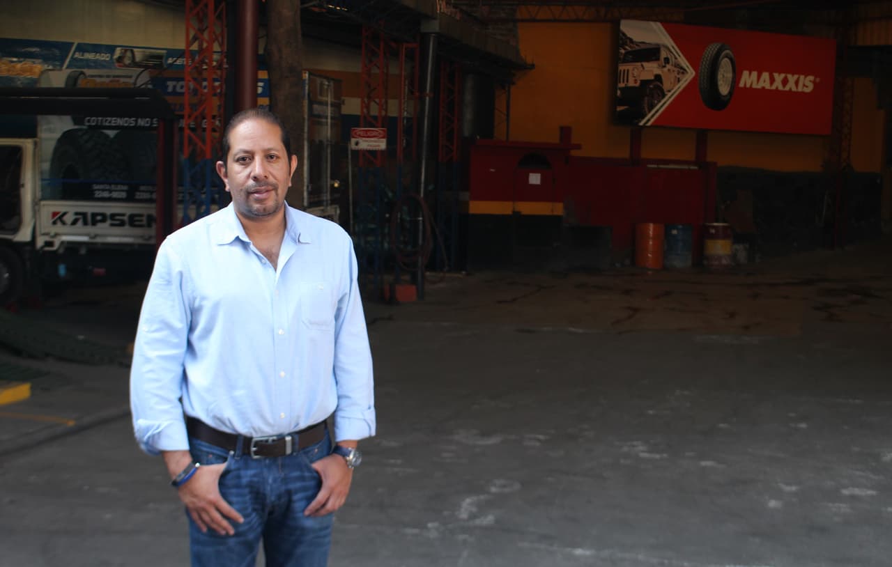 José Mario Escobar, candidato a diputado por San Salvador, frente a su tienda de neumáticos.