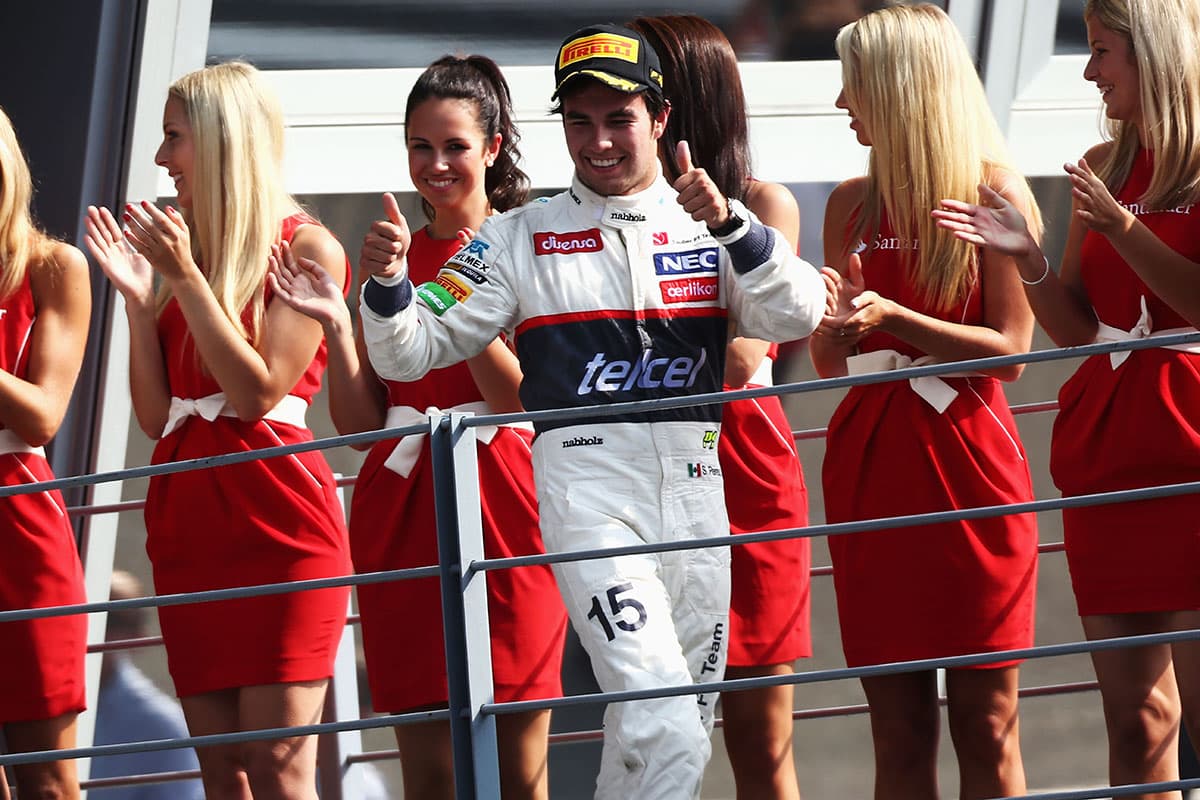 Junto a las
<i>paddock girls</i>, el mexicano Checo Pérez en su tercer podio del 2012 en el Gran Premio de Italia.
