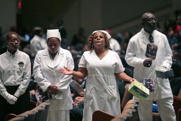 Dentro del templo sonaban los cantos de gospel ante un ataúd gris flanqueado de retratos del difunto.