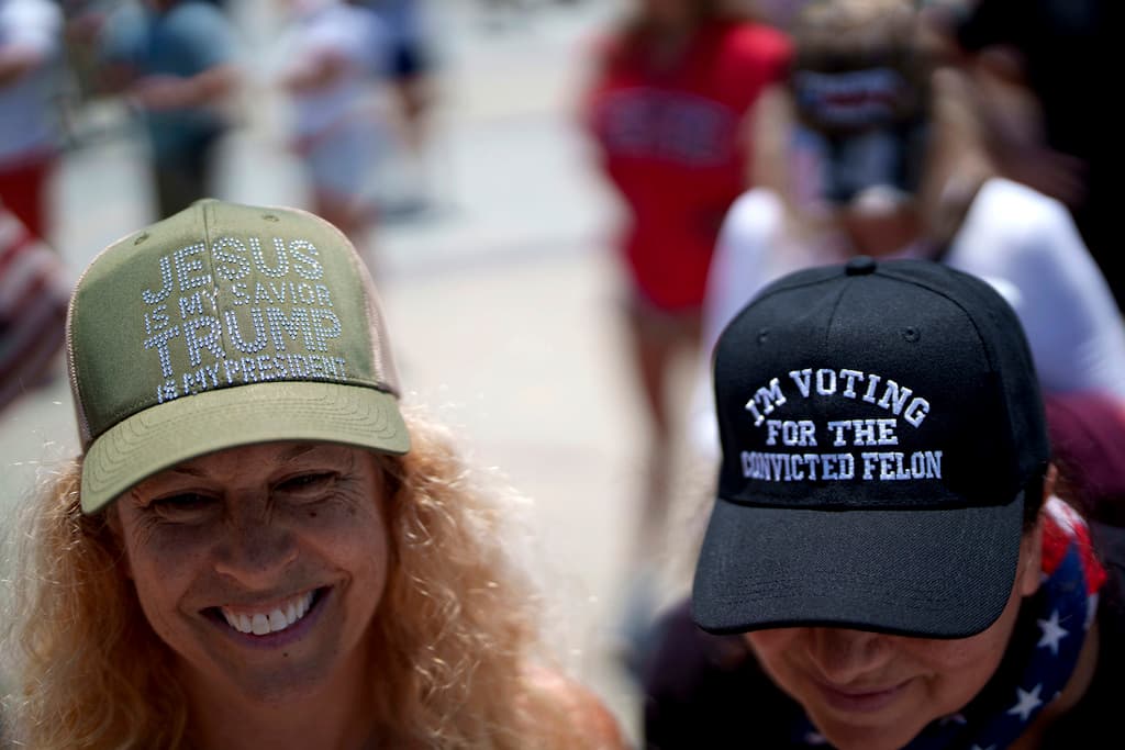 Este dúo, por su parte, llevaba en sus gorras los mensajes "Jesús es mi salvador, Trump es mi presidente" y "Voy a votar por 
<b><a href="https://www.univision.com/local/los-angeles-kmex/politica-los-angeles/elecciones-en-estados-unidos-2024/atentado-a-trump-como-impacta-a-los-votantes-el-intento-de-asesinato-a-un-expresidente-de-cara-a-las-elecciones-video" target="_blank">un delincuente convicto</a></b>".