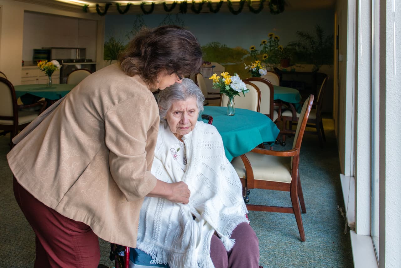 Bárbara Márquez envuelve en un chal a su madre antes de llevarla a pasear.