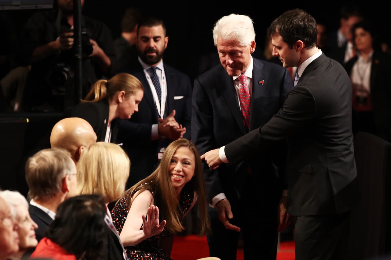 Bill y Chelsea Clinton saludan antes del comienzo del debate.