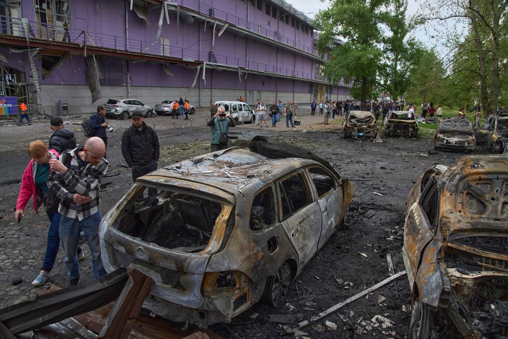 Ucranianos miran sus carros quemados tras un bombardeo ruso en Kiev el 4 de mayo de 2025.