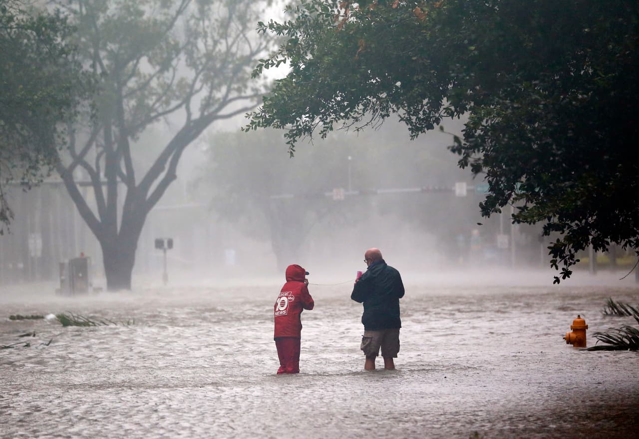 Un equipo de noticias de televisión se mete en una calle inundada en el ditrito Brickell de Miami este domingo. Además de las tormentas, hay alertas de tornados en muchas áreas del estado.
