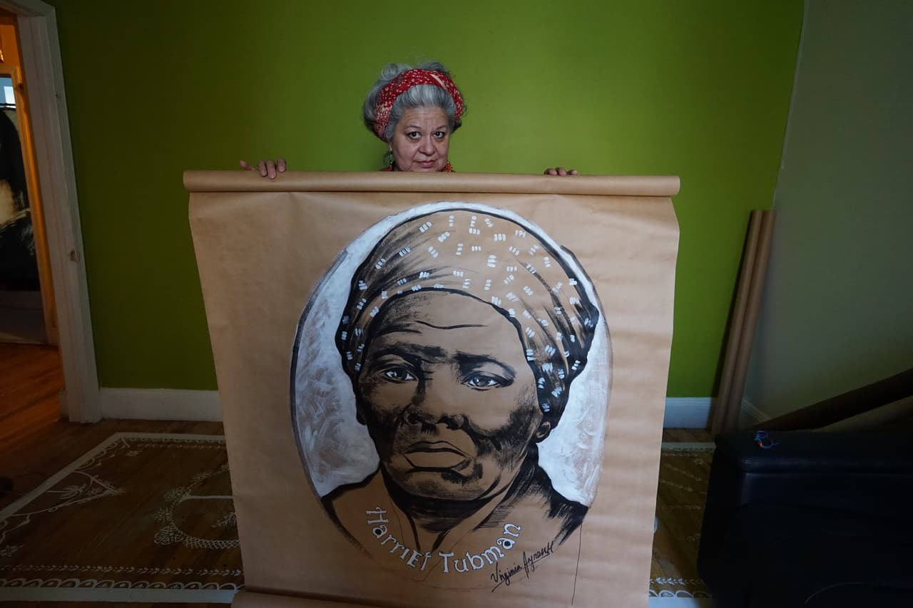 Virginia Ayress mostrando el retrato de Tubman hecho con pintura acrílica.