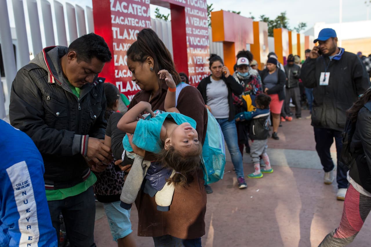 La migrante Sairy Hueso, su esposo y su hija Etzabe Ponce espera en la fila donde se les entregará un número para comenzar el proceso de solicitud de asilo en EEUU.