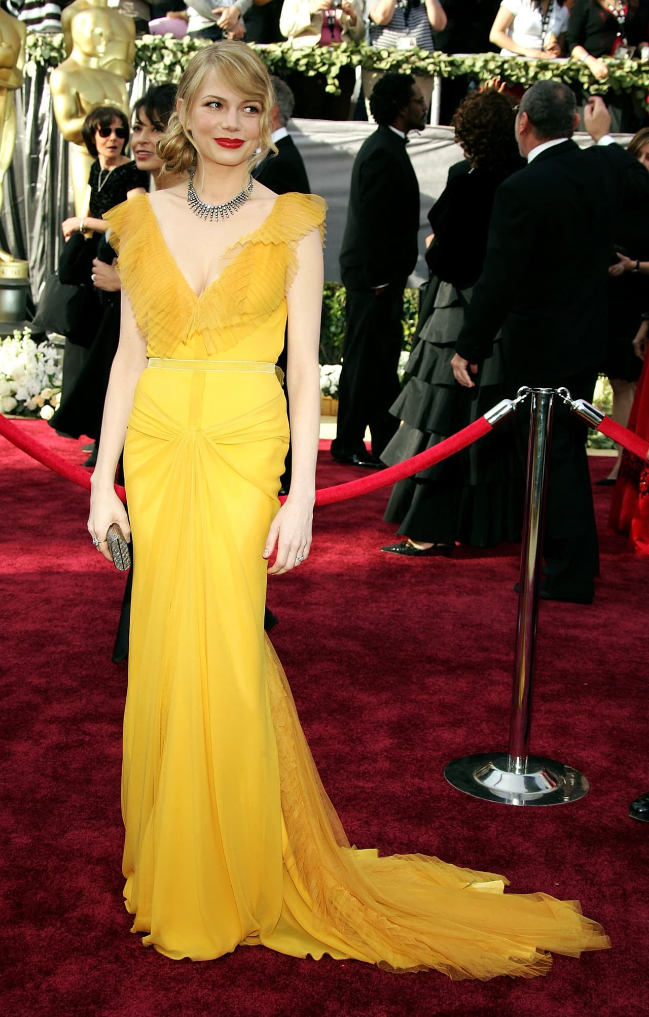 Michelle Williams, en su traje amarillo quemado, creado por Vera Wang para los Oscar en 2006 parece en sí misma una princesa de Disney. Los labios rojos y los vaporosos boleros sin duda harían que Bella se viera aún más ceremoniosa en su baile.