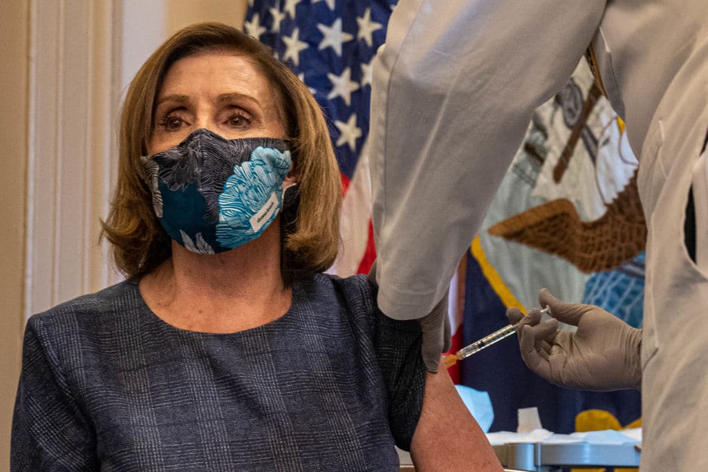 La presidenta de la Cámara de Representantes, Nancy Pelosi, recibe una Tarjeta de Registro de Vacunas luego de que le aplicaran la vacuna contra el covid-19. A su lado, el doctor Brian Monahan, médico asistente del Congreso, en su oficina en Washington DC, este 18 de diciembre de 2020.