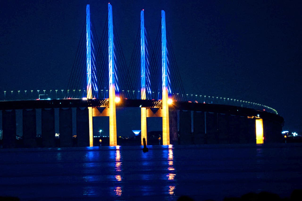 Los pilares de 200 metros de altura del puente Oresund, que une a Dinamarca con Suecia, iluminados de amarillo y azul el 26 de febrero.