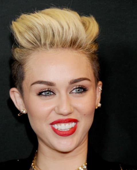 Aunque de manera más discreta, la artista Miley Cyrus también ha utilizado joyería en sus dentadura. En este caso completó su look con ellos para el evento de lanzamiento de Myspace en el 2013.