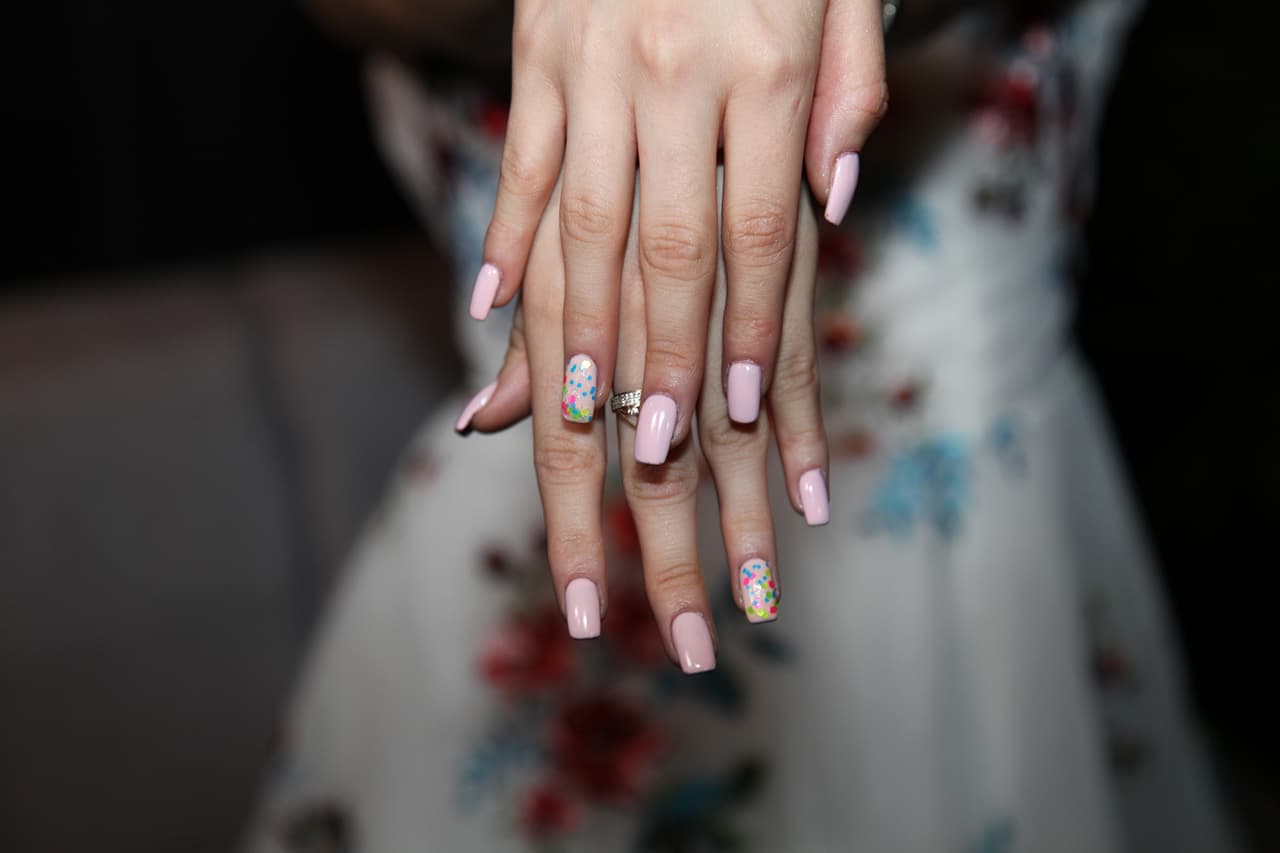 Para completar el atuendo. Karol optó por unas uñas color palo de rosa y en el dedo anular llevó una lluvia de colores, que hacían juego con su colorido vestido.