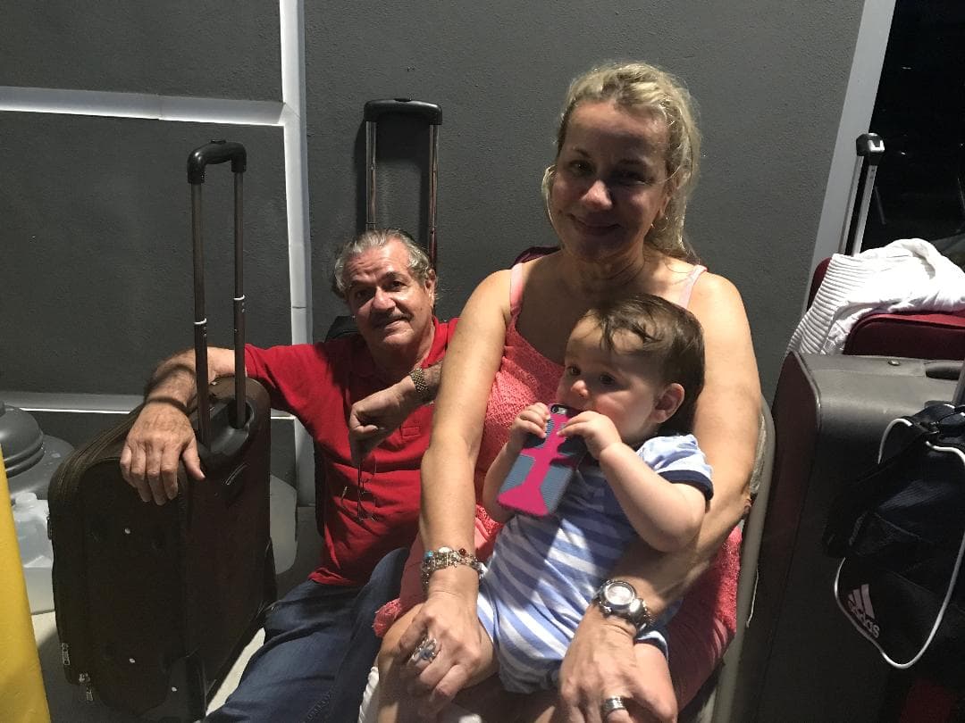 La familia Reyes espera en una terminal aérea privada para partir a Austin, Texas, donde reside una hija.