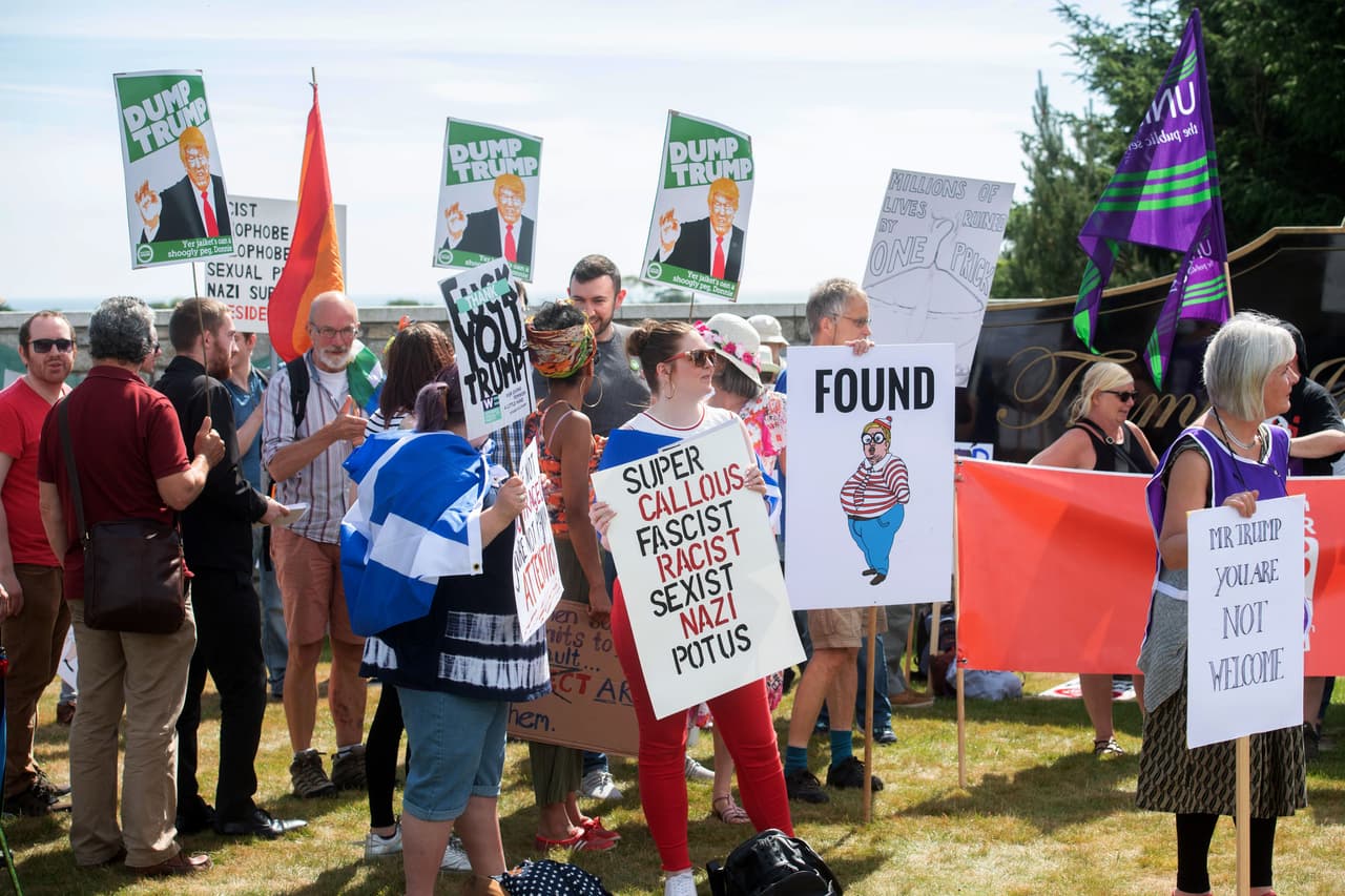 Calificándolo de infantil y de torpe, decenas de personas se pararon a las afueras del campo de golf con carteles que tildan al mandatario de “facista, racista, sexista”. . 
<br>
