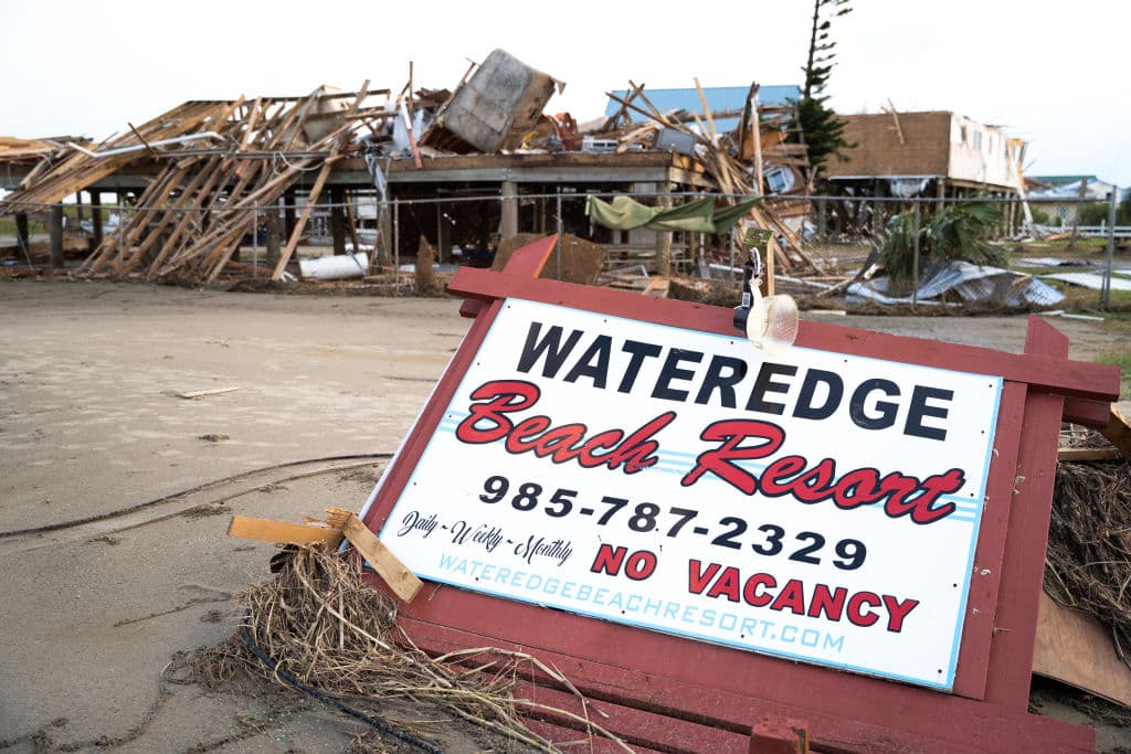 A sign for a beach resort rests among storm debris in the wake of Hurricane Ida on September 4, 2021 in Grand Isle, Louisiana.