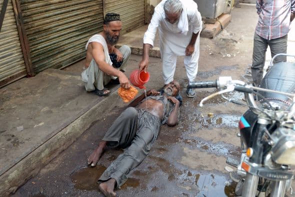 Buena parte de las víctimas son personas de más de 60 años. Un hombre golpeado por el calor en el área del mercado recibe ayuda de voluntarios.